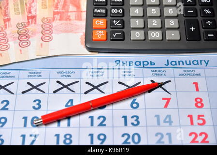 Calcolatrice elettronica, penna rossa, note di cinque mila rubli sono sul calendario holiday 1 gennaio. business still life Foto Stock