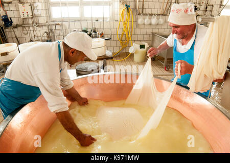 Casari preparare per avvolgere e sollevare la cagliata da un rame iva durante il formaggio parmigiano-reggiano il processo di fabbricazione Foto Stock