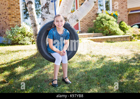 Ritratto di ragazza sulla rotazione dei pneumatici Foto Stock