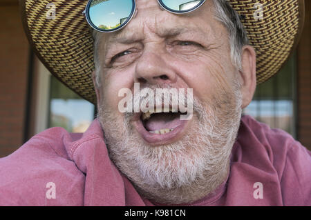 Close-up verticale del barbuto cantando uomo senior Foto Stock