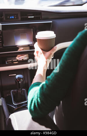 Sezione intermedia dell'uomo avente il caffè in auto Foto Stock