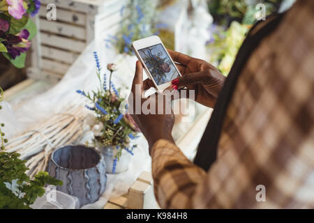 Close-up di fiorista femmina tenendo la fotografia sul telefono mobile del mazzo di fiori Foto Stock