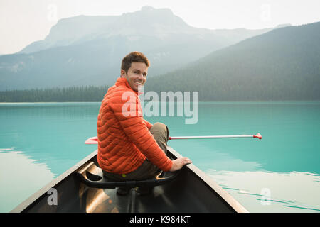 Uomo seduto in un kayak barca nel lago Foto Stock