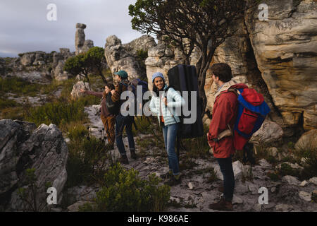 Gruppo di escursionisti in piedi con zaino in spalla durante l'alpinismo Foto Stock