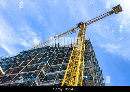 Ampia ponteggio fornire piattaforme per lavori in corso su un nuovo blocco di appartamenti. sito in costruzione. alloggiamento il funzionamento della gru. alto della sede, Foto Stock