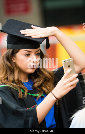 Istruzione superiore nel Regno Unito: Aberystwyth gli studenti universitari di prendere una fotografia selfie indossando accademici tradizionali abiti e schede di mortaio sul loro giorno di graduazione, luglio 2017 Foto Stock