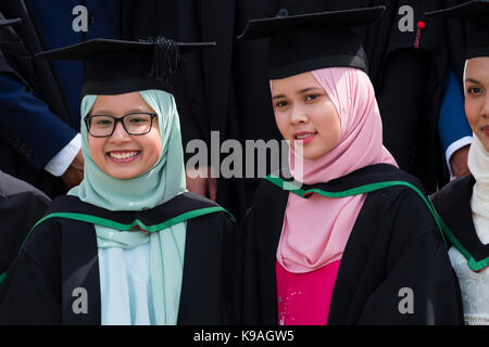 Istruzione superiore nel Regno Unito: un gruppo di stranieri asiatici oltremare aberystwyth studenti universitari indossando accademici tradizionali abiti e schede di mortaio sul loro giorno di graduazione, luglio 2017 Foto Stock
