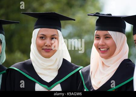 Istruzione superiore nel Regno Unito: un gruppo di stranieri asiatici oltremare aberystwyth studenti universitari indossando accademici tradizionali abiti e schede di mortaio sul loro giorno di graduazione, luglio 2017 Foto Stock
