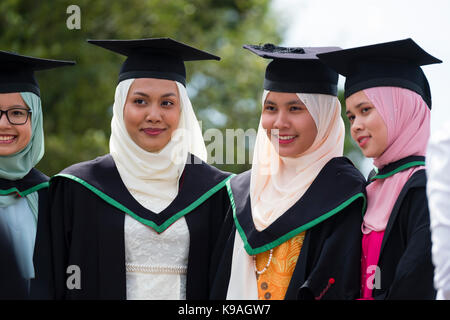 Istruzione superiore nel Regno Unito: un gruppo di stranieri asiatici oltremare aberystwyth studenti universitari indossando accademici tradizionali abiti e schede di mortaio sul loro giorno di graduazione, luglio 2017 Foto Stock