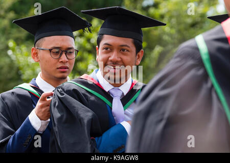 Istruzione superiore nel Regno Unito: un gruppo di stranieri asiatici oltremare aberystwyth studenti universitari indossando accademici tradizionali abiti e schede di mortaio sul loro giorno di graduazione, luglio 2017 Foto Stock