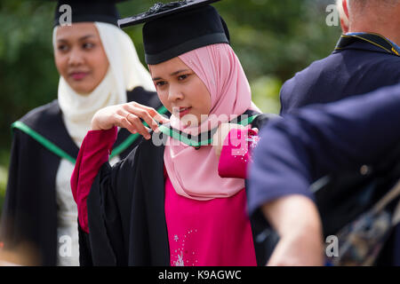 Istruzione superiore nel Regno Unito: un gruppo di stranieri asiatici oltremare aberystwyth studenti universitari indossando accademici tradizionali abiti e schede di mortaio sul loro giorno di graduazione, luglio 2017 Foto Stock
