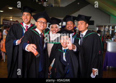 Istruzione superiore nel Regno Unito: un gruppo di stranieri asiatici oltremare Aberystwyth studenti universitari indossando accademici tradizionali abiti e schede di mortaio di prendere una fotografia selfie sul loro giorno di graduazione, Luglio 2017 Foto Stock
