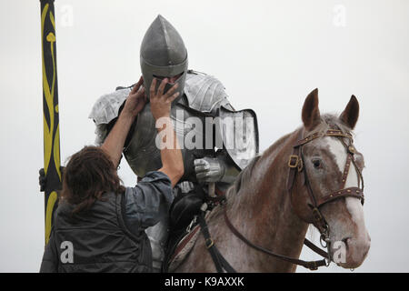 Membro del personale fissa armatura medievale sul attore ceco Michal Bednář vestito come un cavaliere medievale durante le riprese del nuovo film tedesco 'Die Ritter' ('I Cavalieri") diretto da Carsten Gutschmidt per ordine del ZDF in Milovice nella Boemia centrale, Repubblica Ceca in 23 ottobre 2013. Foto Stock