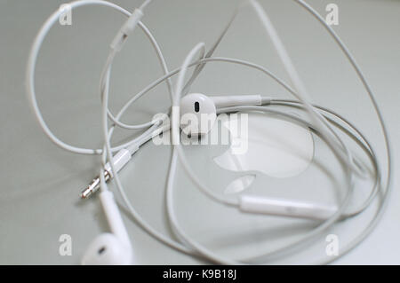 Apple EarPods rannicchiato sulla sommità di un MacBook Pro Foto Stock