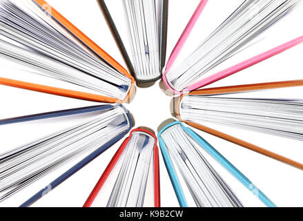 Vista dall'alto di libri colorati in un cerchio su sfondo bianco Foto Stock