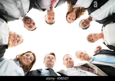 Direttamente sotto il ritratto di fiducioso team aziendale in piedi in huddle contro uno sfondo bianco Foto Stock