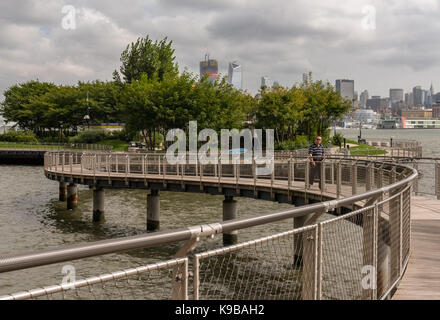 Hoboken, NJ USA -- Settembre 19, 2017 --uomo cammina lungo un avvolgimento waterfront marciapiede in hoboken. solo uso editoriale. Foto Stock