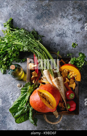 Varietà di raccolto autunnale verdura carota, pastinaca, bietole, paprica, hokkaido zucca, porcini e funghi finferli nel vassoio in legno su te grigio Foto Stock