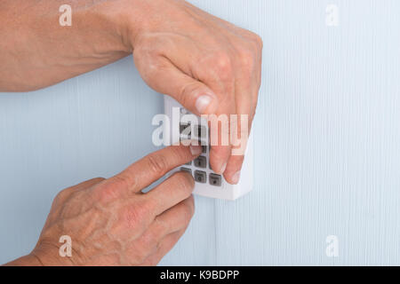 Close-up di una mano immettendo il PIN nel sistema di sicurezza Foto Stock