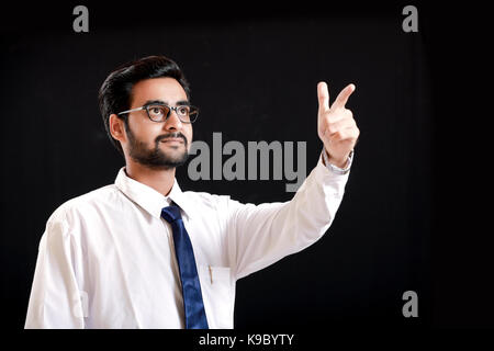 Indian giovane uomo che mostrano la direzione con la mano Foto Stock