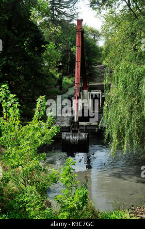 Le attrezzature di dragaggio di clearing limo di fondo al di fuori del canale del fiume. Foto Stock