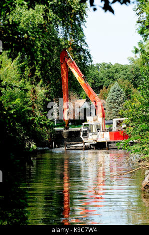 Le attrezzature di dragaggio di clearing limo di fondo al di fuori del canale del fiume. Foto Stock