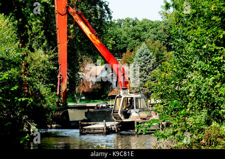 Le attrezzature di dragaggio di clearing limo di fondo al di fuori del canale del fiume. Foto Stock