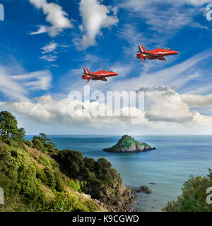 Composito di due aviogetti Hawk da frecce rosse aerobatic team volando a bassa quota sopra la Thatcher rock, Torquay in Devon Regno unito su una soleggiata giornata estiva. Foto Stock