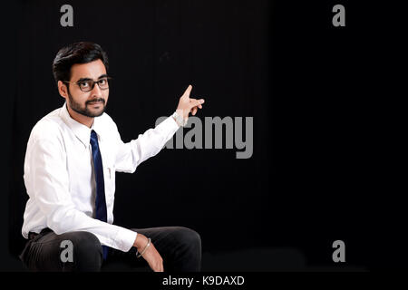 Indian giovane uomo che mostrano la direzione con la mano Foto Stock