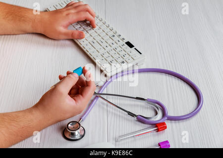 Esperimenti in laboratorio le mani del medico presso la tabella tiene nelle mani di un tubo di prova Foto Stock