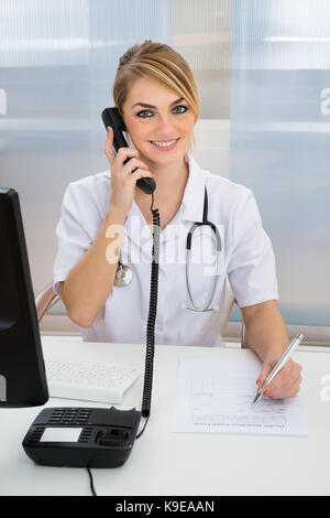 Ritratto di giovane donna medico parlando al telefono Foto Stock