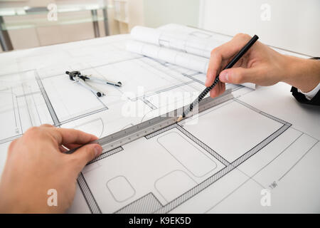 Close-up di ingegnere diagrammi di disegno con la matita e il righello sulla carta cianografica Foto Stock