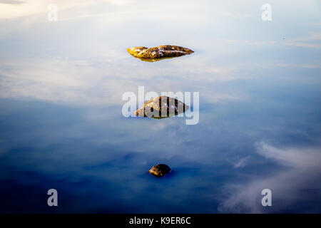 La riflessione di un paio di rocce nel asciugata lago padulu tortu sull isola di Corsica. Foto Stock