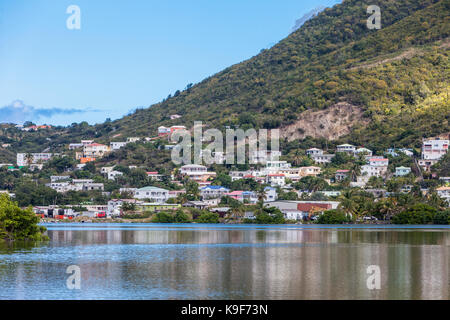 Philipsburg, Sint Maarten. Case risalendo la collina attraverso il grande stagno di sale. Foto Stock