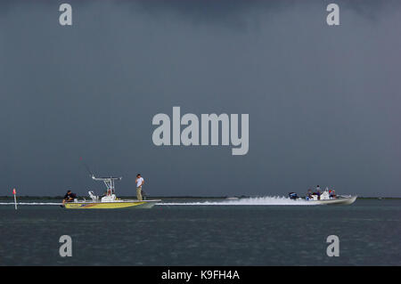 I pescatori a parlare su un telefono cellulare una tempesta mentre la pesca durante un temporale vicino a Port Aransas, Texas Foto Stock