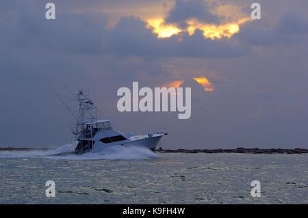 Un profondo mare sport fishing boat capi a sunrise vicino sporti a Port Aransas, Texas Foto Stock