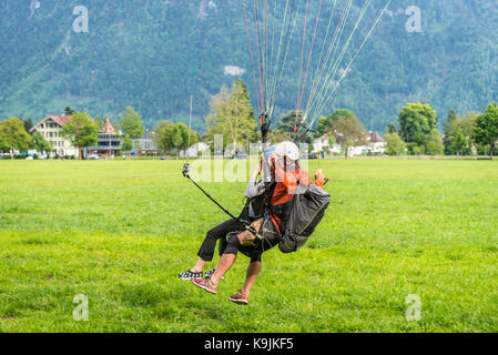 Interlaken, Svizzera - 26 maggio 2016: parapendio in tandem atterra dopo un volo sopra le alpi svizzere in Interlaken, Svizzera. Foto Stock