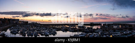 Alba cielo sopra il mare e il Porto di Ramsgate. Il marina Yachting in primo piano, il sorgere del sole sull'orizzonte con cloud rotto sopra di sotto-lit. In cima alla scogliera punto di vista, Vista panoramica. Foto Stock