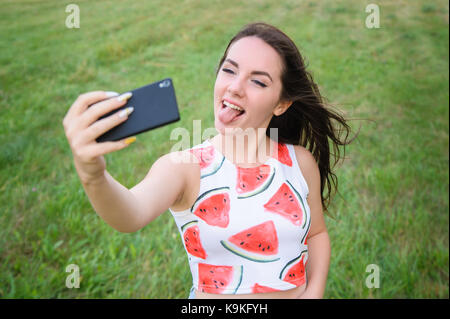 Giovane bella ragazza facendo selfie al tramonto Foto Stock