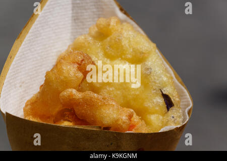 Gamberetti, le patate e le verdure in pastella, fritti . cucina di strada in imballaggio di cartone. arrosto, fritture di pesce e verdure. Foto Stock