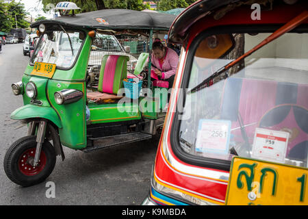 Donna, autista, in attesa di clienti, tre ruote, taxi Tuk Tuk, a Khao San Road, Bangkok, Thailandia Foto Stock