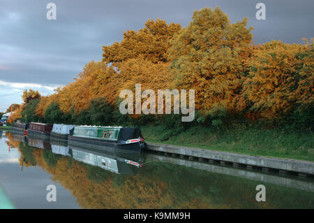 Sole di sera sugli alberi, strette barche ormeggiate al norton junction, Grand Union Canal, Leicester sezione, Watford Gap, daventry, Warwickshire, Inghilterra. Foto Stock