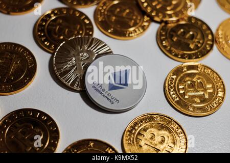 Valuta digitale fisico ethereum grigio moneta vicino bitcoins oro. Foto Stock