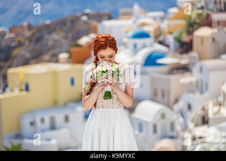Bellissimi i capelli rossi sposa con un bouquet di fiori Foto Stock