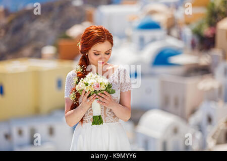 Bellissimi i capelli rossi sposa con un bouquet di fiori Foto Stock