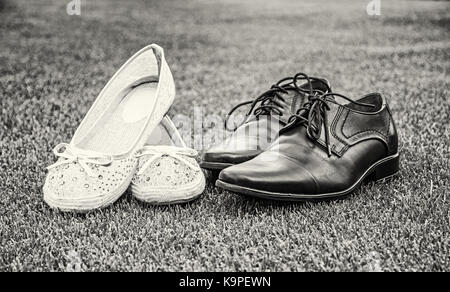 Donne e uomini scarpe matrimonio sull'erba verde. Il simbolo dell'amore. foto in bianco e nero. Foto Stock