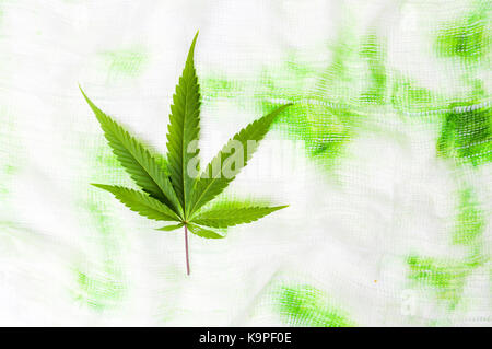 La marijuana foglia verde sul colorato sfondo tessili Foto Stock