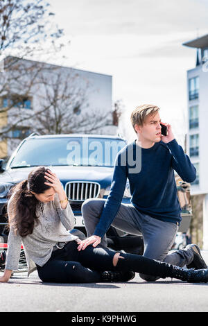 Preoccupato per il giovane driver chiamando l'ambulanza dopo aver colpito incidente Foto Stock