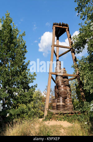 Un vecchio cosacco torre di avvistamento in legno su di una collina nel mezzo di una foresta che è servito come un segnale di avviso e contro un cielo blu con una nuvola bianca Foto Stock