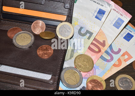 Portafoglio in pelle con varie banconote e monete in euro Foto Stock